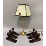 A brass table lamp with shade together with six metal doorstops