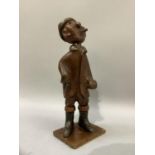 An Italian carved hardwood figure of a man smoking a cheroot, a hat on his head, a knapsack on his