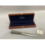 A Royal Selangor pewter paper knife, the handle chased with stylised flowers contained in a blue