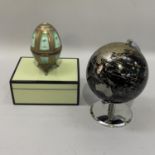 A black and pale gilt globe on chrome stand, 23cm high, a pale green and black box 20cm by 15cm by