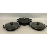 A set of cast iron cookware by Jean-Patrique including a two-handled pan and cover and a pair of