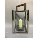 A candle lantern with glass and chrome frame and wooden handle, 45cm x 29cm