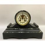 A Victorian black and grey marble mantel clock with drum movement, having a white enamel two part