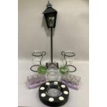 A pair of glass candle lamps in black metal holders together with a sectional ring of tealights in