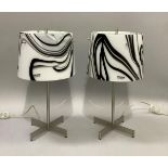 A pair of AV Mezzega Murano glass table lamps, the shades having swirls of black on white, on a