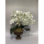 A faux orchid held in an urn on square base, approximately 70cm high