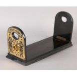 A MID 19TH CENTURY EBONISED AND CUT BRASS MOUNTED BOOK SLIDE, the end panels of arched outline,