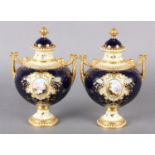 A PAIR OF COALPORT CHINA TWO HANDLED VASES AND DOMED COVERS with bud finial, each painted with a