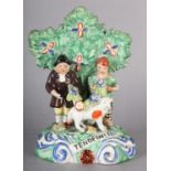 A 19TH CENTURY WALTON POTTERY FIGURE GROUP 'TENDERNESS', farmer and his wife, with sheep before a