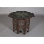 A 19TH CENTURY INDIAN CARVED AND PIERCED FOLDING TABLE, the inset copper tray top of scalloped