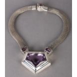 AN AMETHYST NECKLACE collet set to the centre with a pentagonal faceted stone flanked by two smaller
