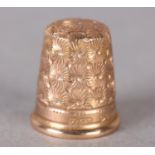 A GEORGE V THIMBLE in 9ct gold by Charles Horner Ltd, all over dandelion seed patterned in