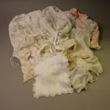 Fine, early, 20th century knitted baby or doll jackets and bonnets, with a wide range of stitches,