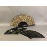 Three fans, the first late 19th century, wood sticks painted black and mounted with a fabric leaf of
