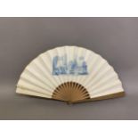 A 19th century printed fan with wood monture showing a formal family scene, in a grand house,