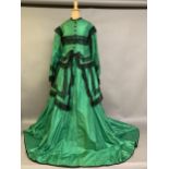 A vibrant emerald green two-piece 1850’s costume, the bodice with long, pagoda sleeves, trimmed with