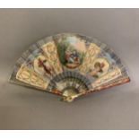 An attractive early 20th century silk fan with double leaf, the recto painted with a cartouche of