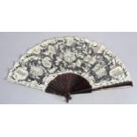 c1905, a black net and mixed Brussels lace fan, the unusual needle lace floral motifs applied to