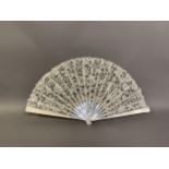 A large c 1890s white mother of pearl and Bruges bobbin lace fan, of floral design, guard approx.