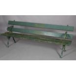 An early 20th century garden bench with planked back and seat with rustic cast iron supports,