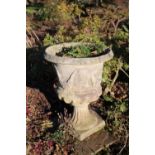 A cast garden urn with reeded lower body on fluted socle and square base, 40cm diameter x 53cm high