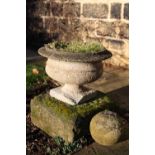 A cast urn on square stone base together with a stone ball, base 47cm square, urn 46cm wide x 34cm