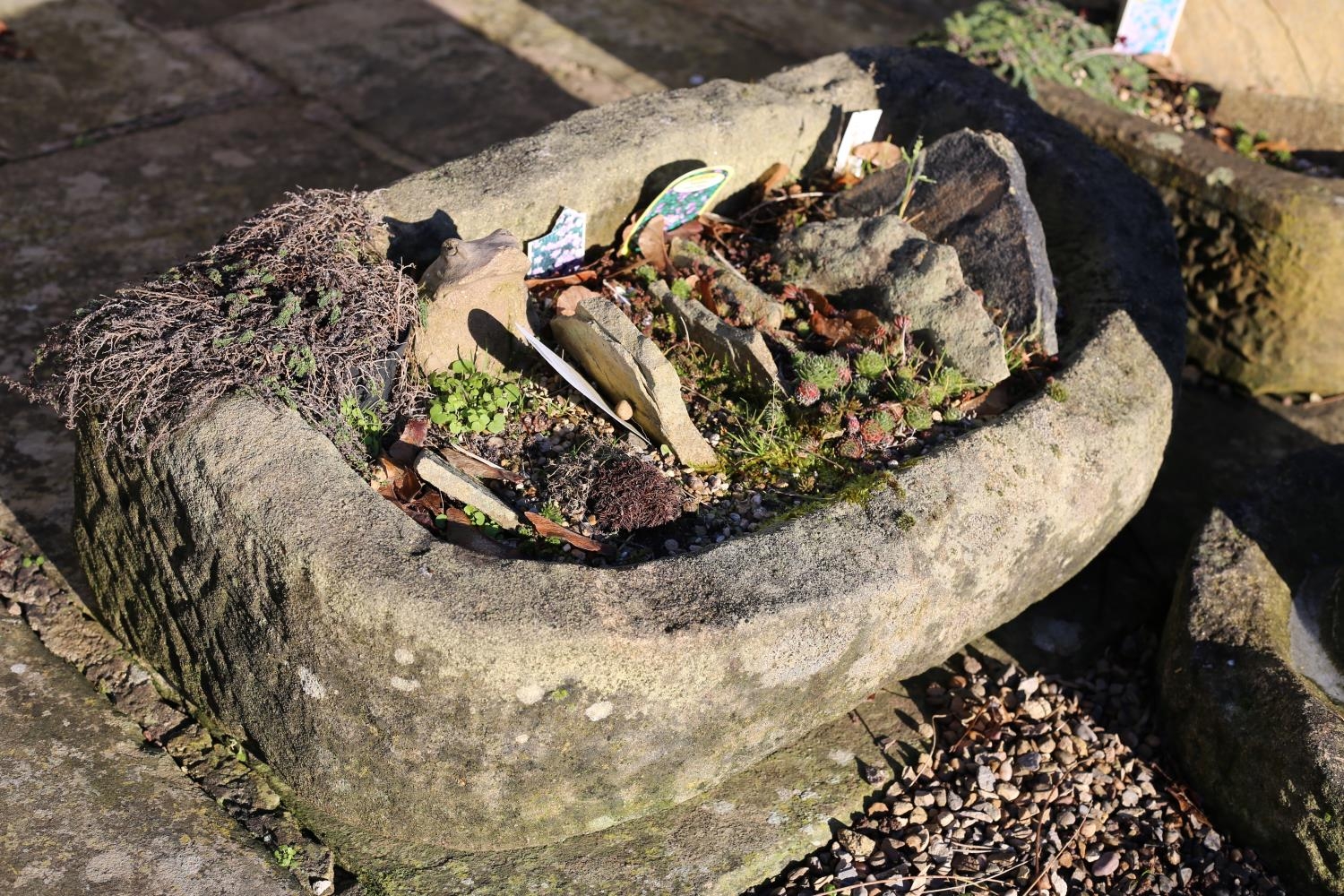 A semi-circular stone trough, flat back, 74cm x 43cm x 26cm