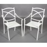 A pair of white metal strapwork garden chairs