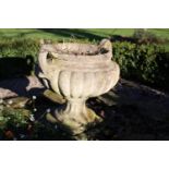 A small cast two handled urn of campagna shape with lobed body and fluted socle on square plinth