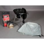 A Weber compact kettle charcoal barbeque, with cover, bag of briquettes and two bags of lighter