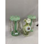 A pair of pale green glass lustres hung with prismatic drops, tapered column and on circular domed