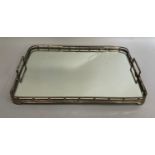 An early 20th EPNS and mirrored two-handled tray, rectangular with rounded corners having a bar