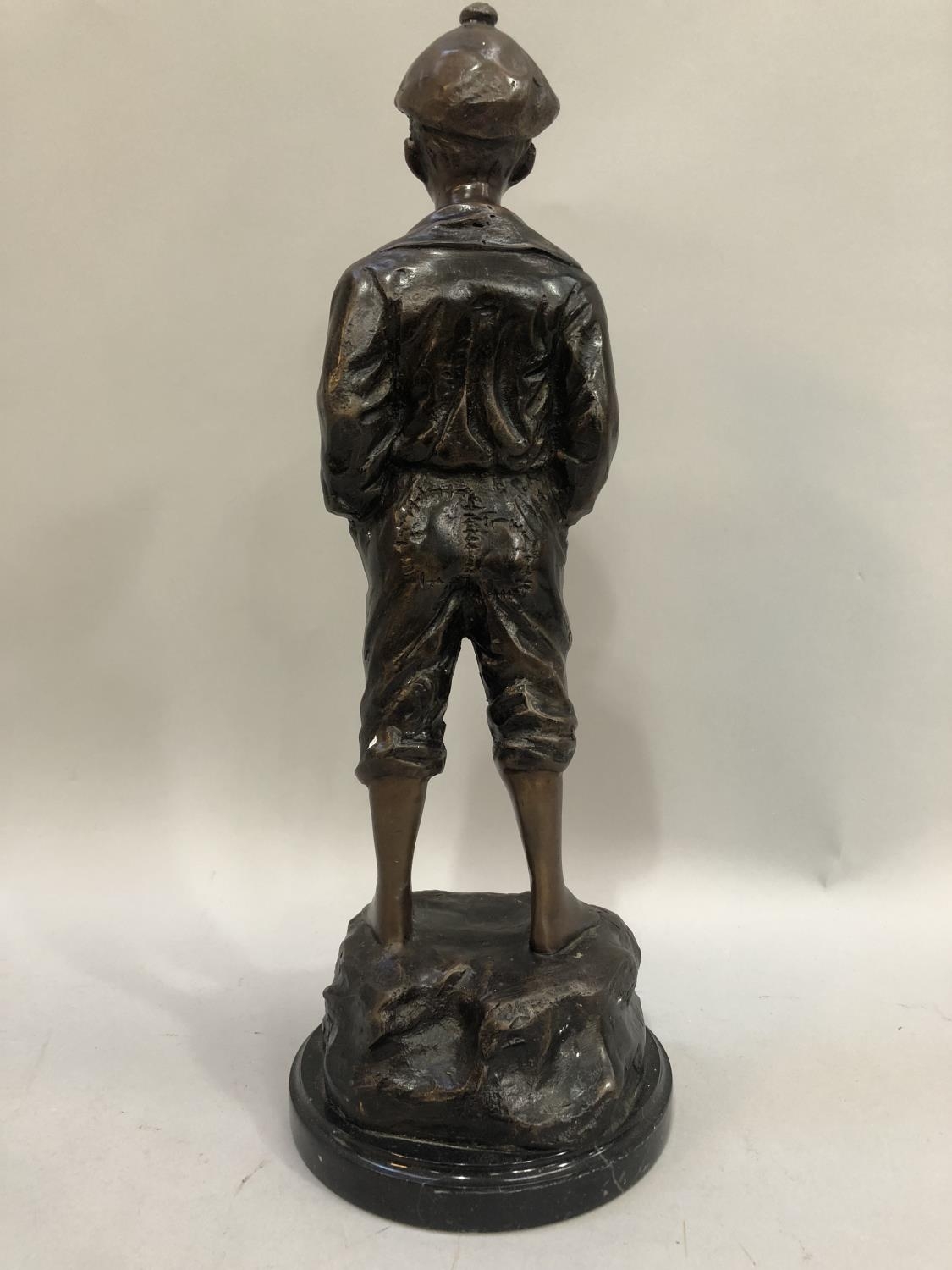 A reproduction bronzed figure of a young boy wearing a cap, hands in his pockets and trousers rolled - Image 2 of 3