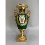 A French porcelain two handled vase of baluster form, the body gilt with laurel wreath and lyre on a