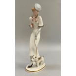 A Hutschenreuther china figure of a 1930's lady in elegant attire walking her dog, on oval base with