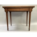 An Edwardian card table with fold over top lined with baize and on square tabled legs with spade