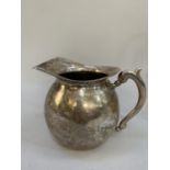 An early 20th century jug bowl form will extended open lip and cast handle in whole metal (test as