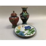 Three items of Chinese cloisonné ware including a baluster vase and domed cover of red ground, a