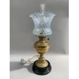 A Victorian brass and black glass oil lamp with chimney and opaque shade