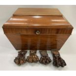 A mahogany wine cooler of sarcophagus shape, the paw feet with casters currently detached but