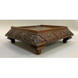 Carved walnut stand on stepped ball feet, decorated with carved ivy, 25cm wide