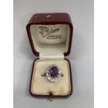 An amethyst and diamond cluster ring in 9ct gold, the oval facetted amethyst claw set within a