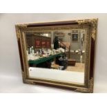 Burgundy and gilt framed wall mirror of rectangular outline with bevelled glass, 68cm x 77cm