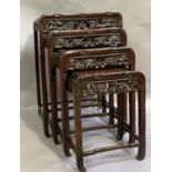 A nest of four Chinese hardwood tables with faux bamboo carved frame and opposing dragon carved