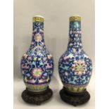 A pair of 20th century famille rose Chinese vases, the bottle shaped bodies enamelled in famille