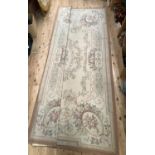 An aubusson rug, woven with flowers in oval reserves in pale pinks, greens and browns, approximately
