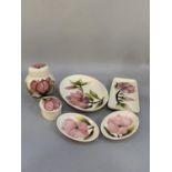 Six items of Moorcroft magnolia tube lined and glazed in pink on a cream ground comprising lidded