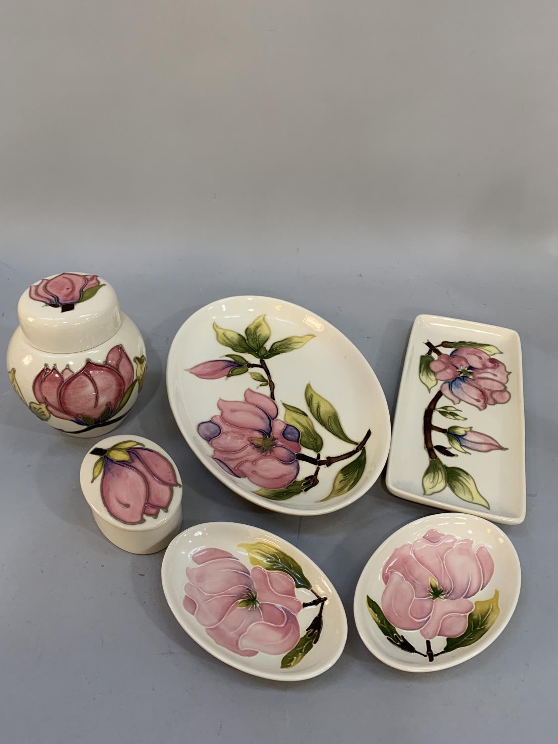 Six items of Moorcroft magnolia tube lined and glazed in pink on a cream ground comprising lidded - Image 2 of 3