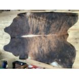 A large cow hide rug, approx 240cm long