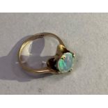 An opal doublet ring in 9ct gold, the oval cabochon stone claw set in a deep fluted setting,